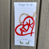 Things to do ADK notepad paired with a red meta ADK in a heart ornament.
