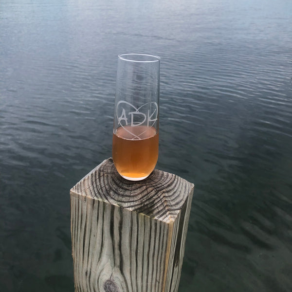 ADK in a heart on a stemless champagne flute