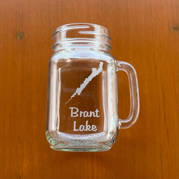 Brant Lake Clear glass handled mason jar with the silhouette of Brant Lake etched on it and Brant Lake text below the lake.