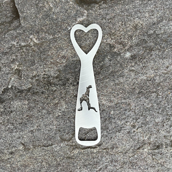 Silhouette of Loon Lake cut out on a stainless steel bottle opener. It has a heart cutout at the top of the opener.