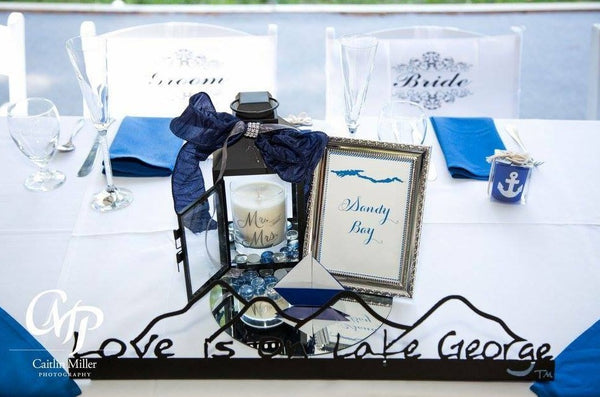 Love is on Lake George text on a metal sign with the cutout of the Mountains; graphite.