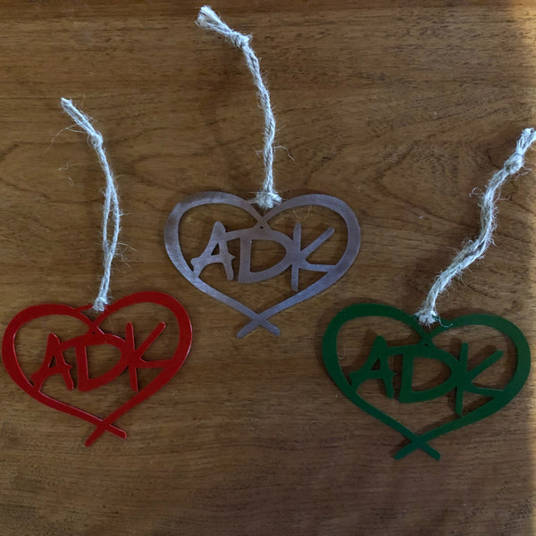 3 Adirondack metal ornaments. The design in ADK in a heart with a hand tied twine hanger. The set includes a red, green and stainless ornament.