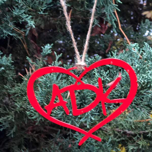 ADK in a heart metal ornament with a natural hemp hand tied hanger; color red.