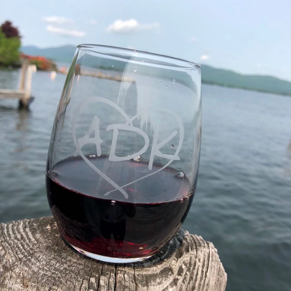 Clear stemless wine glass with our ADK logo etched inside a heart.
