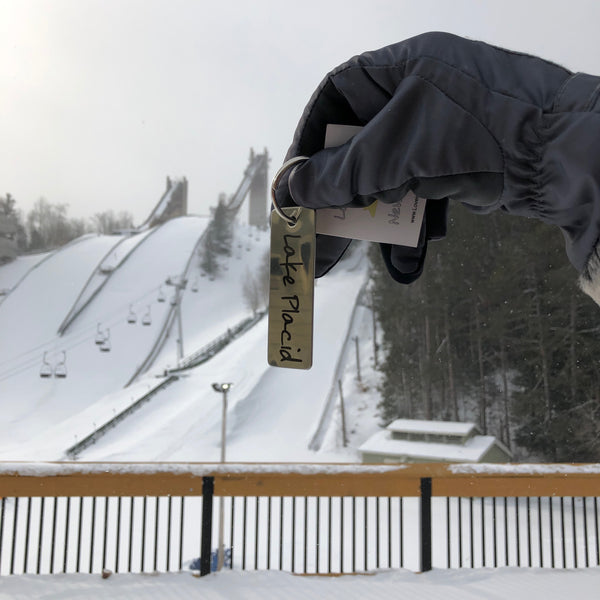 Lake Placid text on a stainless key tag with ring; key chain.