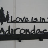 Love is in the Adirondacks text with a cluster of 3 pine trees on a 4 hook wall mount.