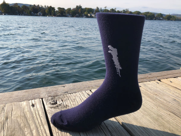 Silhouette of Brant Lake stitched in white on a unisex navy blue sock.