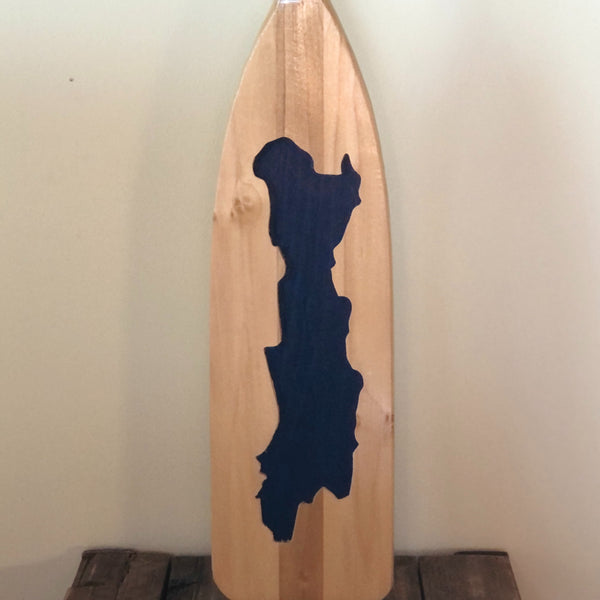 The silhouette of Friends Lake etched on the blade of a 5' wooden canoe paddle . The lake is painted blue.