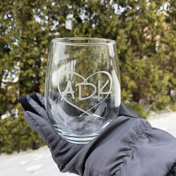Clear stemless wine glass with our ADK logo inside a heart.