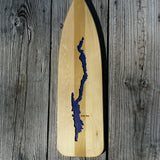 Silhouette of Lake George milled out of a canoe oar; the lake is painted blue.