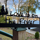 Love is on the Rivert text on a black metal foor hook wall mount with some ADK trees.