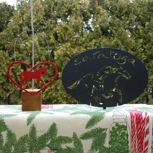 Horse in a heart ornament. Saratoga text arched over a jockey riding a horse trivet.