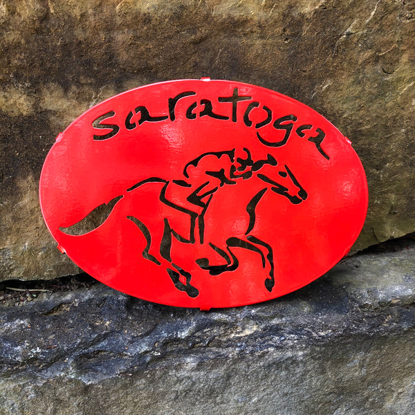 Saratoga text arched over a jockey riding a horse; Color red.