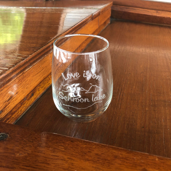 Clear stemless wine glass with a lake and mountain scene. Text reads Love is on Schroon Lake