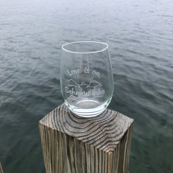 Clear stemless wine glass with a lake and mountain scene. Text reads Love is on Schroon Lake