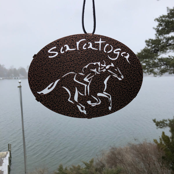 Saratoga text arched over a jockey riding a horse; color black.