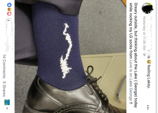 Navy blue sock with white stiching of the silhoeutte of Lake George.