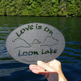 Text Love is on Loon Lake text with the outline of the lake and surrounding Adirondack mountainscape
