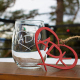 ADK in a heart hand blasted onto a clear stemless wine glass paired with an red metal ADK in a heart ornament and wine bottle necklace.