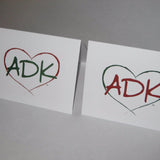 Two Adirondack note cards have our interlocking Love is in the Adirondacks ADK Heart silhouette in alternating colors; ADK Green text inside a red heart; ADK red text inside a green heart on white note card stock.