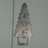 Handcrafted stainless steel bottle opener with a ADK cut out of an Adirondack evergreen tree. The bottle opener tab is at the base of the tree.
