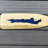 Silhouette of Brant Lake etched on a wood paddle blade and painted blue.  BRANT LAKE text below the lake silhouette