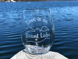 Clear stemless wine glass with a lake and mountain scene.  Text reads Love is on Brant Lake
