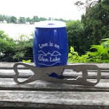 Love is on Glen Lake text in white on a blue plastic cup with a mountain and lake scene.  It is paired with a stainless Silhouette of Glen Lake Bottle Opener