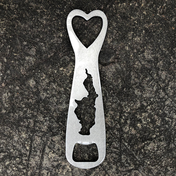 Metal bottle opener with a heart cut out on the top, silhouette of Glen Lake cut out in the body, and bottle opener cut out at the bottom.