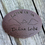 Love is in Indian Lake text  cut out  with our Lake and mountain scene on a copper penny metal trivet.