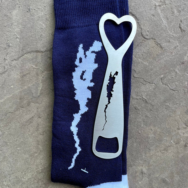 Pair of navy blue unisex socks with the silhouette of Lake Champlain and a stainless bottle opener.