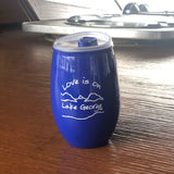 Love is on Lake George text over our lake and mountain scene printed on a 15 oz  stemless plastic wine tumbler or cocktail classic glass.  Text is white; cup is lake blue.
