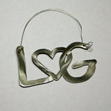 Ornament with the letters LG with an interlocking heart with a metal hanger .