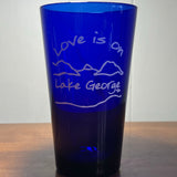 Love is on Lake George text over/under our Lake/Mountain scene; printed in white on a blue glass.
