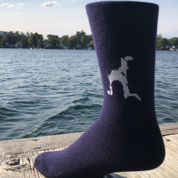 Silhouette of Loon Lake stitched in white on a unisex navy blue sock.