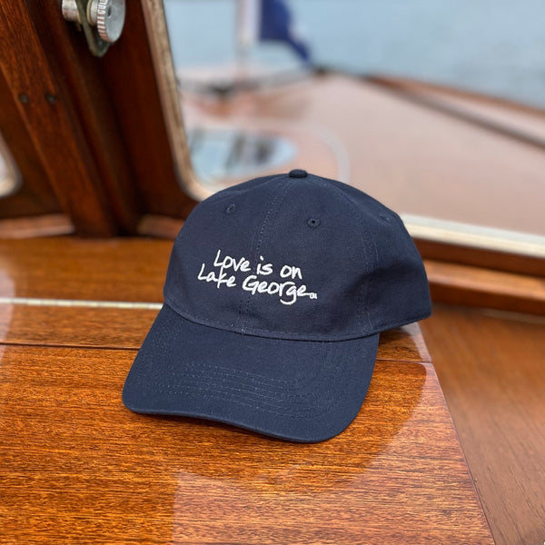 Navy Blue unisex ball cap with Love is on Lake George embroidered on it.