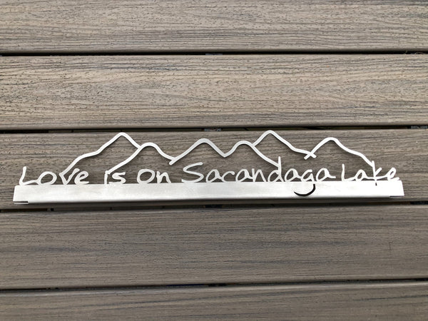 Love is on Sacandaga Lake text on a stainless metal sign with mountains.